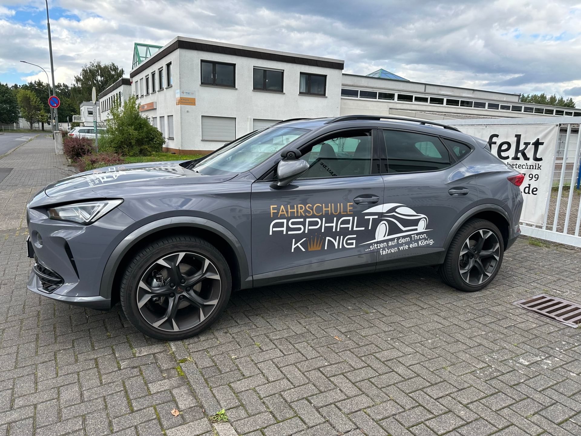 SUV der Fahrschule Asphaltkönig mit weiß-goldener Beschriftung