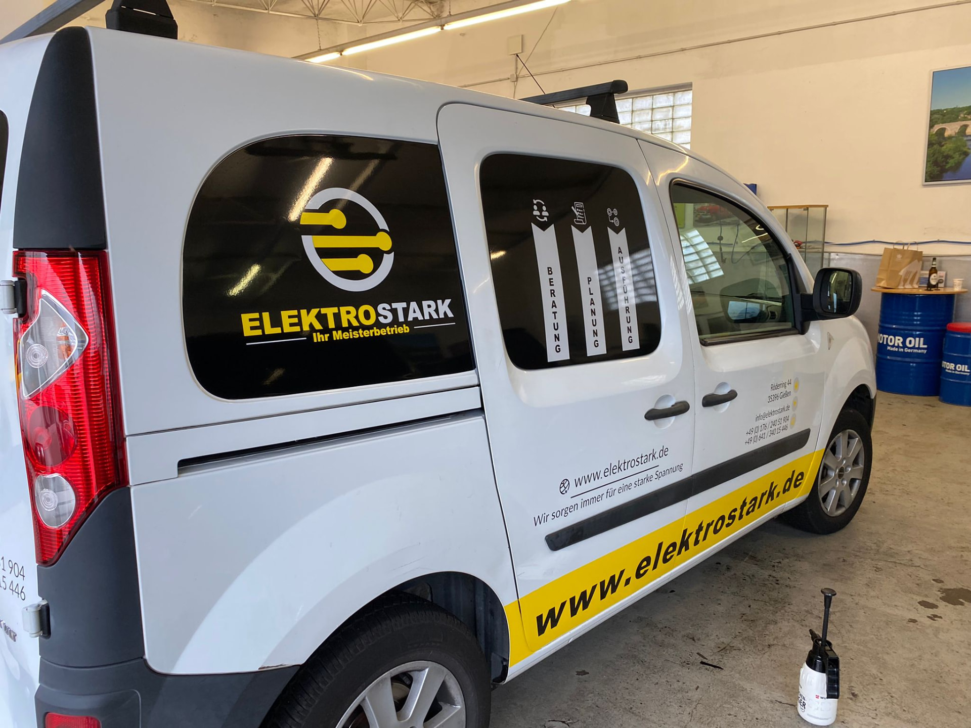 Transporter von ElektroStark mit Heckfenster-Gestaltung und gelbem Website-Schriftzug