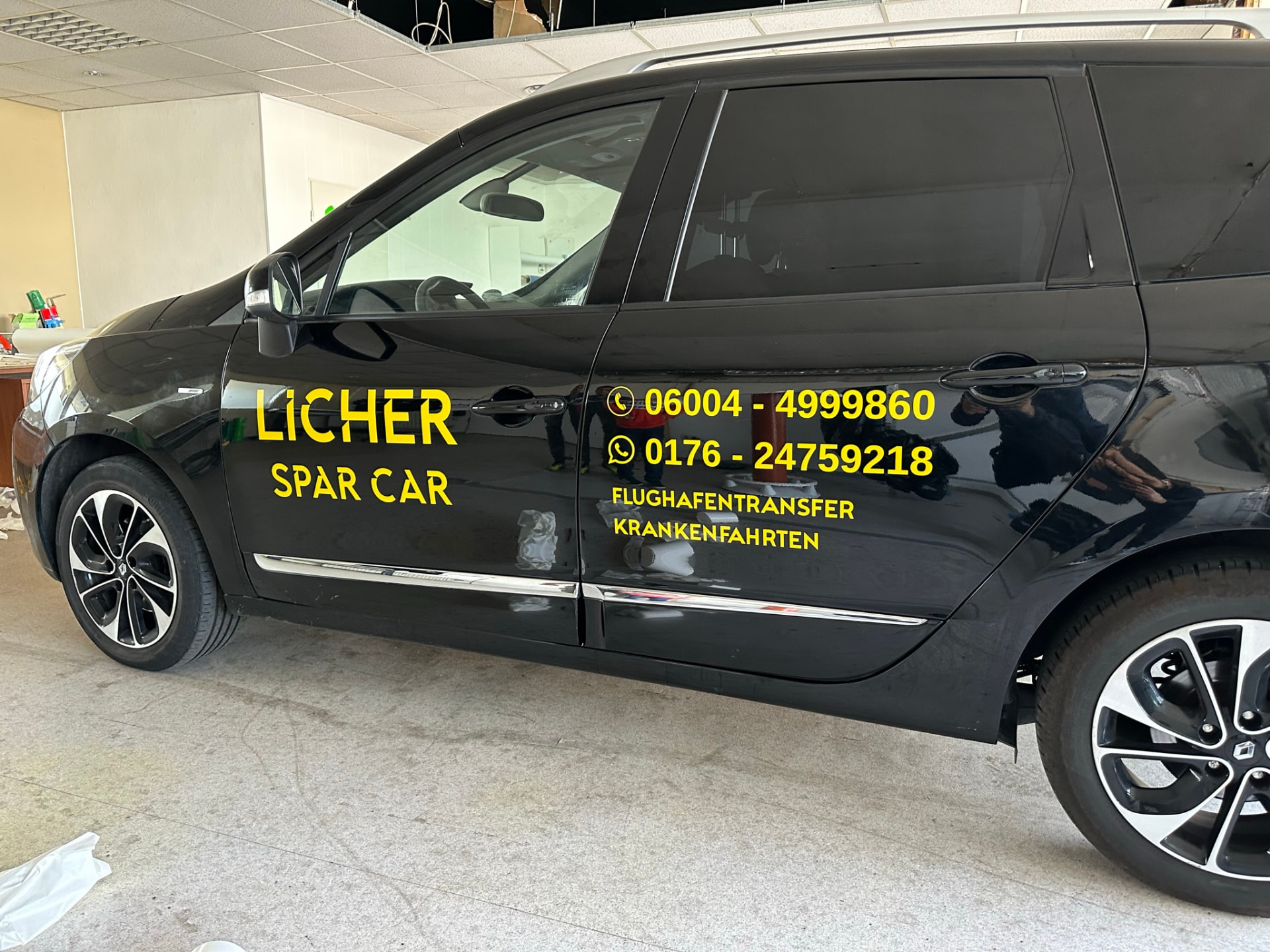 Kombi von Licher Spar Car mit gelber Beschriftung und Telefonnummern