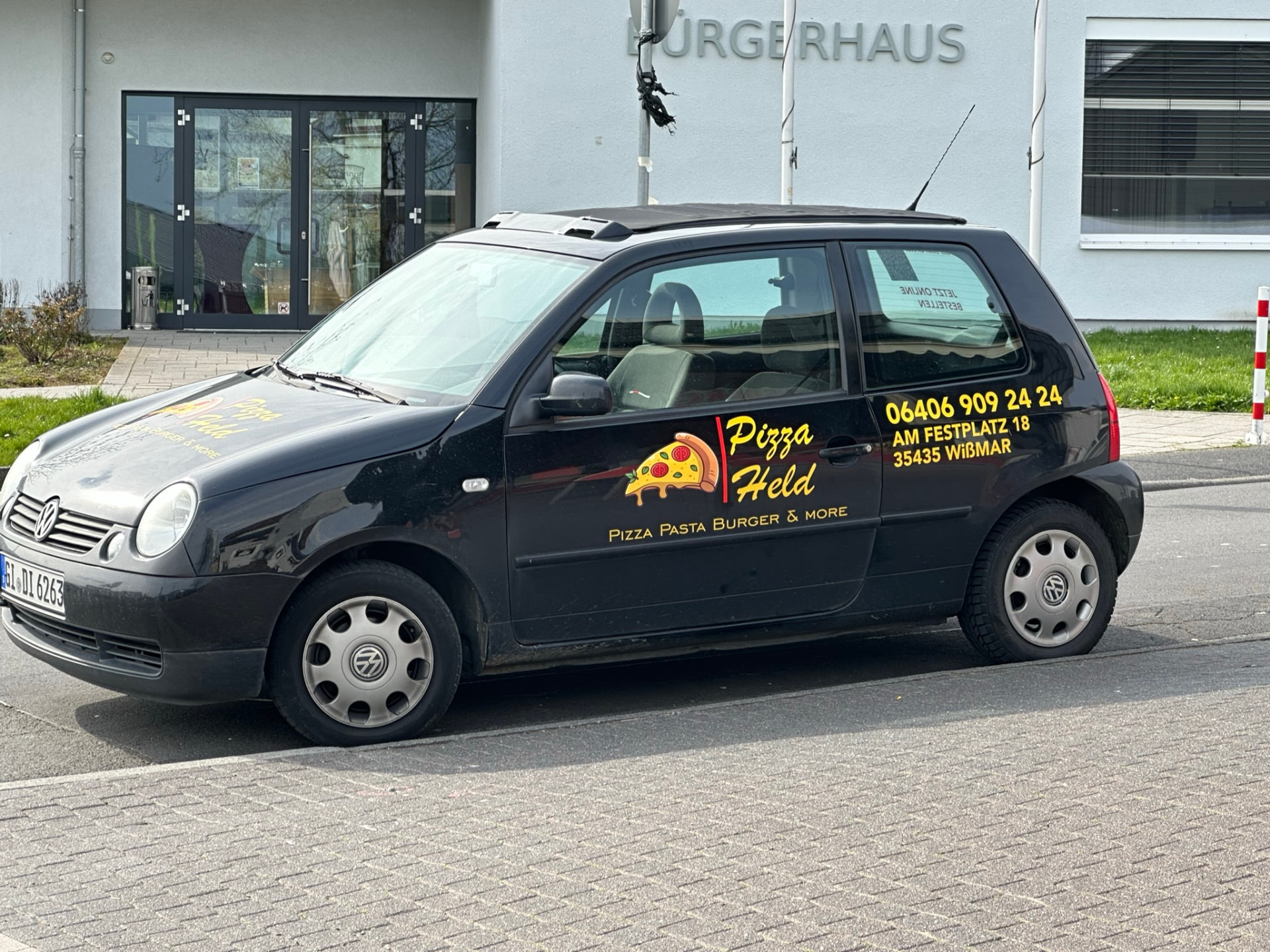 Kleiner Lieferwagen von Pizza Held mit Logo und Bestellnummer
